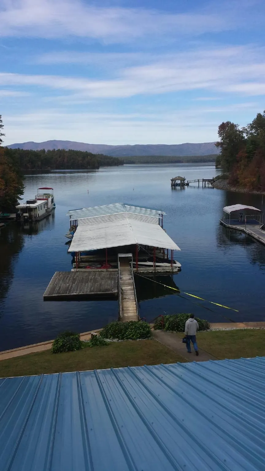 View across a lake from a newly installed blue metal roof in Stanley